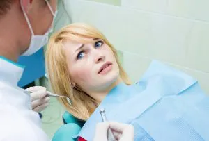 Patient sitting in a dental chair looking anxious