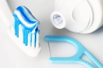 Toothbrush with toothpaste and a flossing tool